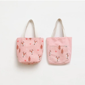 Detail showing printed deer pattern and exterior pocket on pink canvas tote bag