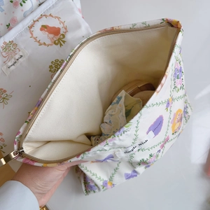 Detail showing inner lining and metal zipper of floral canvas makeup storage bag