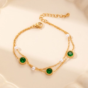 Double-layered gold bracelet with green emerald-colored zircons and white pearls