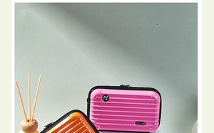 Pink and orange hard shell mini makeup bags with vertical stripes and zip closure