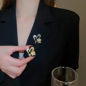 Elegant gold double heart brooch with sparkling rhinestones on a black suit lapel