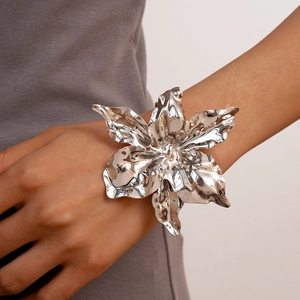 Detailed macro view of an oversized silver flower cuff bracelet with liquid metal texture