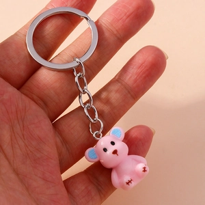 Close-up of cute pink bear keychain with blue ear accents and silver metal ring