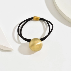 Macro view of minimalist dual-strand black hair tie with a brushed golden bead ornament