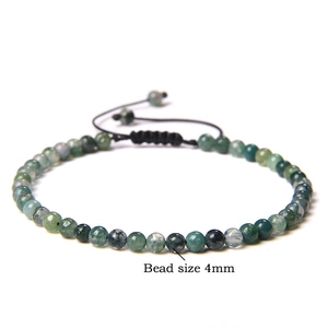 Detail view of 4mm natural green moss agate beads on adjustable black woven cord bracelet
