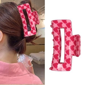 Pince à cheveux rose avec motifs de cœurs rouges et vue portée par mannequin