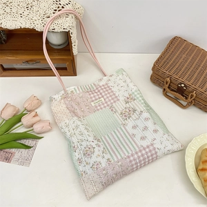 Floral patchwork tote bag with lace detail and pink handles in a picnic scene setting