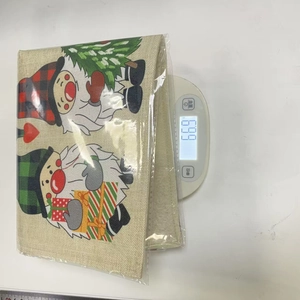 Detailed view of burlap Christmas gnome placemats with plaid hats being weighed on a scale
