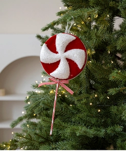 Detail of red and white glitter candy lollipop ornament with a silk bow on Christmas tree