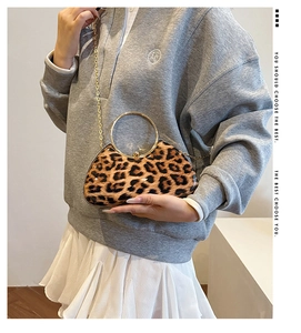 Detail of leopard print hard shell clutch bag with gold round handle and chain strap