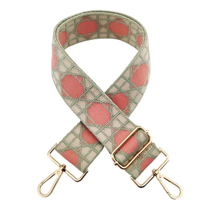 Close-up of pink geometric jacquard bag strap with golden metal lobster clasps