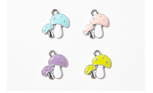 Detail view of four colorful enamel mushroom pendants for DIY jewelry and keychains
