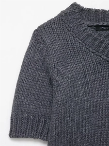 Close-up detail of grey round neck knitted short sleeve top showing thick ribbed texture