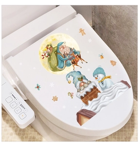 Detail showing Santa Claus and reindeer stickers applied on a white toilet lid lid surface