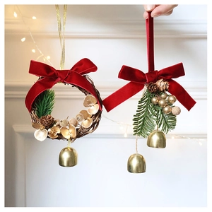 Close-up of Christmas wreath and pine cone ornament with red velvet bow and gold bell