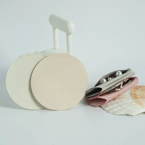 Macro detail of round microfiber jewelry pouches in beige, grey and pink colors