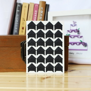 Close-up of black triangular photo corners on kraft paper for DIY scrapbooking albums
