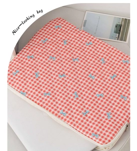 Quilted red plaid tablet sleeve featuring blue bow patterns and a side zipper detail