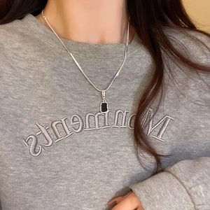 Minimalist silver chain necklace with black rectangular pendant and LUCKY engraving
