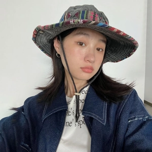 Detail of wide-brim ethnic bucket hat with colorful trim and adjustable chin cord
