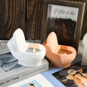 Detailed close-up of burning creative toilet-shaped candles on a rustic wooden background
