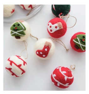 Detail of handmade wool felt Christmas ball ornaments with tree and stocking patterns