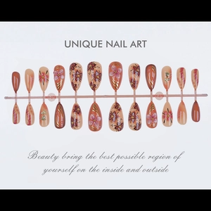 Detailed view of almond-shaped fake nails with hand-painted floral patterns and gold accents