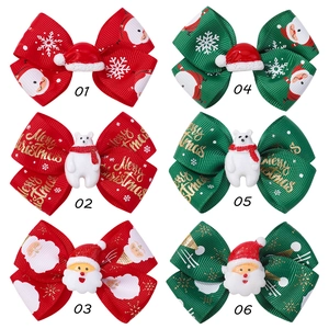Close-up of assorted Christmas bow hair clips with Santa and Snowman holiday 3D details