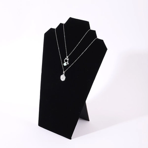 Black velvet necklace display stand with silver pendants on a clean white background
