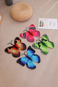 Flat lay of colorful butterfly-shaped plush pillows in pink, orange, green and blue colors