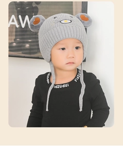 Détail du bonnet en tricot gris pour bébé avec oreilles et broderie souris