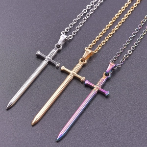 Close-up of three fencing sword necklaces in silver, gold, and iridescent rainbow colors