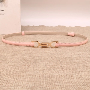 Detail of light pink slim belt with interlocking gold buckle on a linen background