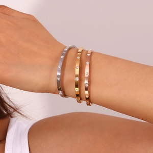 Three-piece bangle set in silver, gold and rose gold with zircon inlay on model's wrist