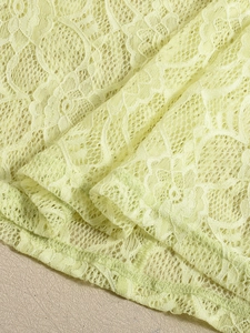 Gros plan sur le tissu en dentelle jaune clair avec des motifs floraux au crochet