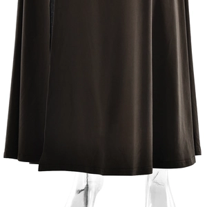 Détail de l'ourlet de la robe noire avec fente latérale élégante et texture de tissu doux