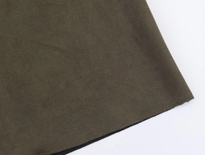 Détail de la texture du tissu vert armée et surpiqûres fines sur l'ourlet du trench-coat