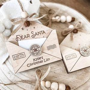 Macro shot of wooden Christmas envelope ornaments with laser-engraved Dear Santa and bells