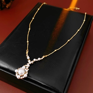 Macro detail of gold plated pearl and zircon pendant on elegant black leather display