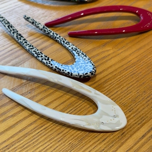 Detail of three acetate hair pins in burgundy, tortoiseshell, and cream with rhinestones
