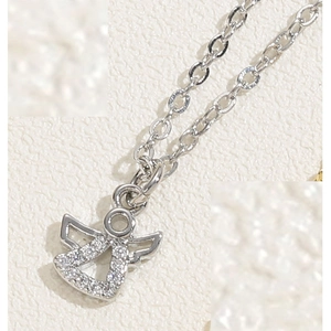 Macro view of silver angel pendant necklace with sparkling cubic zirconia on link chain