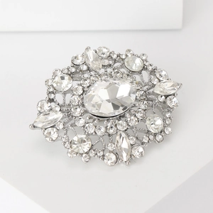 Close-up of vintage silver brooch featuring sparkling oval rhinestones and floral design