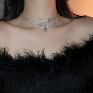 Close-up of silver bow necklace with zircon crystals and drop pendant on a model
