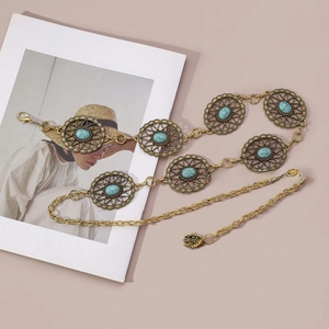 Detailed macro view of vintage bohemian gold belt chain with turquoise stone inlays