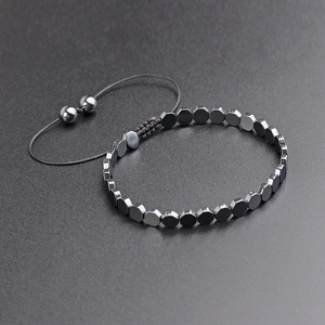 Macro detail of adjustable woven bracelet with geometric gunmetal hexagonal beads