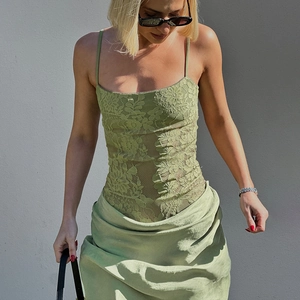 Olive green lace slip bodysuit with floral patterns shown on model in a stylish street shot
