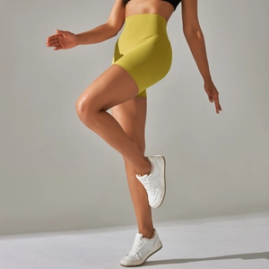 Close-up of high-waist mustard yellow yoga shorts showing seamless elastic fabric texture