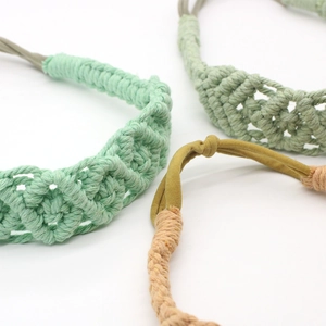 Detailed texture of bohemian hand-woven elastic cotton headbands in mint, olive, and beige