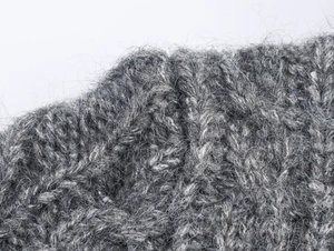 Dettaglio ravvicinato di maglia grossa grigia con fibre di mohair lunghe e morbide
