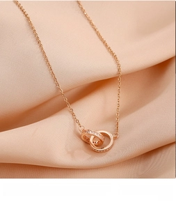Macro detail of rose gold double ring pendant with pavé cubic zirconia and S925 hallmark